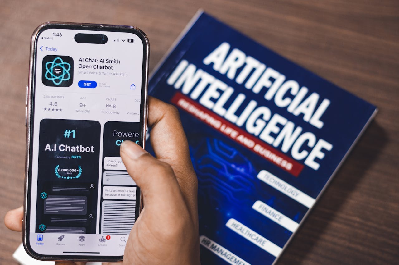 gallery-1 Smartphone displaying AI app with book on AI technology in background.